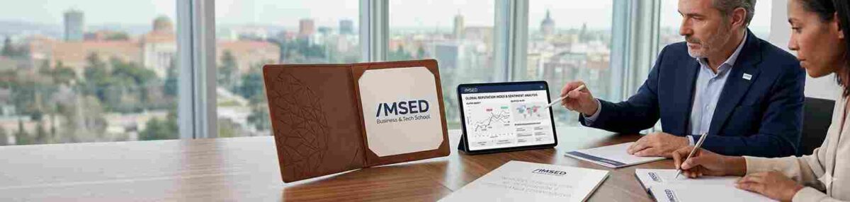 quipo directivo de IMSED Business & Tech School analizando un panel de métricas de reputación global y sentimiento de marca en una tablet, con manuales corporativos de IMSED sobre una mesa de juntas.